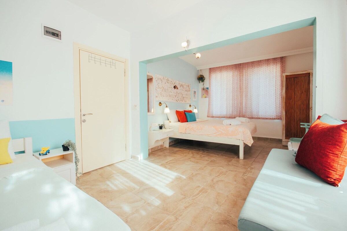 A bedroom with a bed, bedside table, and a window with curtains.