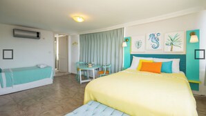 Une chambre d’hôtel comprenant un lit, un coin salon avec une table et des chaises, et un petit bureau.