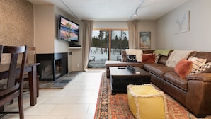 A living room with a fireplace, a sofa, a coffee table, and a television.