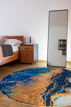 A bedroom with a bed, a nightstand, a dresser, a large mirror, and a blue patterned rug. - Central Cozy & Charming Residence 3min from Riverside Prague (Hlavní mesto Praha)