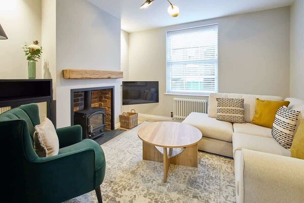 A living room with a fireplace, sofa, and a round coffee table.
