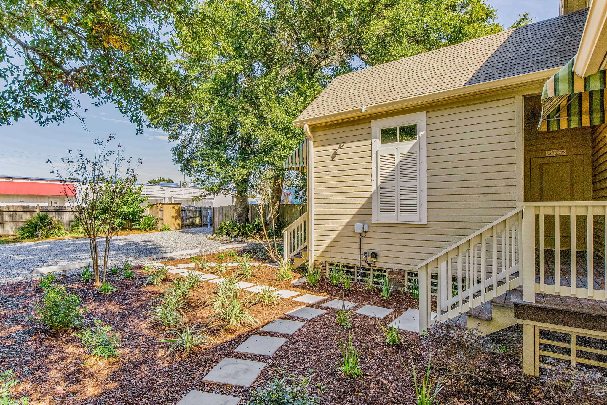 A residential house with a front porch, a small garden with stepping stones, and a mailbox.