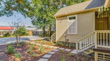 A residential house with a front porch, a small garden with stepping stones, and a mailbox.
