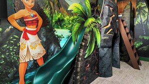 Une pièce dont un mur est décoré d’une fresque représentant un paysage tropical, avec une cascade et des palmiers.