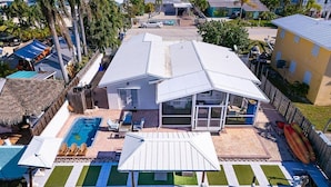A house with a swimming pool, a covered patio, and a fenced yard.