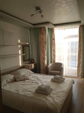 A hotel room with a bed, a chair, a desk, and a window with curtains. - 2-bed - Sleeps 4 - w Parking (Blagoevgrad)