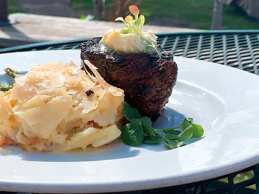 Een bord met steak en aardappelpuree.