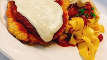 Ein Teller mit Schnitzel, Soße und Pasta.