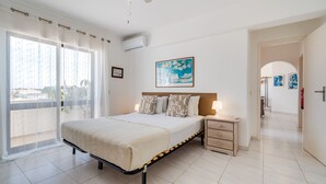 Une chambre à coucher avec un lit, une table de chevet et un tableau accroché au mur.