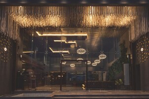 Um interior com luminárias pendentes, entrada de vidro e um relógio visível na parede.