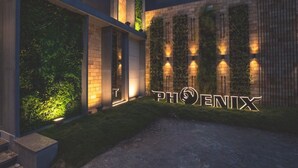 Un edificio moderno con un letrero que dice “PHOENIX” iluminado en la noche.