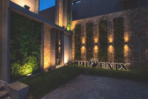 Um edifício moderno com uma placa iluminada que diz 'PHOENIX' à noite.