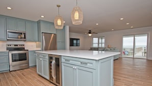 Una cocina amplia con armarios azul claro, electrodomésticos de acero inoxidable y una isla grande.
