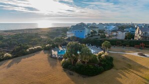 Uma área residencial costeira com casas, piscina e praia.