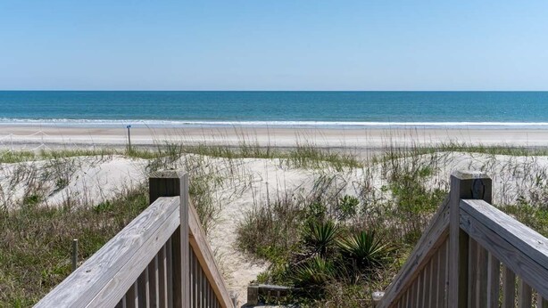 A wooden boardwalk leading to a beach with sand dunes and sparse vegetation. - Sea Castle West, Oceanfront Duplex in Emerald Isle, NC! (Emerald Isle)