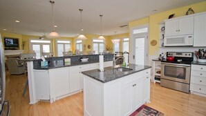 A spacious kitchen with white cabinetry, a granite countertop, and stainless steel appliances. - Sea Notes, Almost Oceanfront House in Emerald Isle, NC! (Emerald Isle)