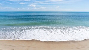 Ein Strand mit klarem, blauem Wasser und einem Sandufer.