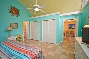 Relax in this serene bedroom with a large bed, ceiling fan, and television.