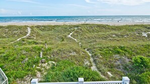 A beach with a grassy area and a path leading to the water. - Swiss House, Oceanfront Home in Atlantic Beach, NC! (Atlantic Beach)