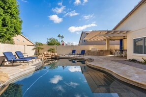 A swimming pool with lounge chairs, a barbecue area, and a patio with a pergola. - Epic 6BR w/ Foosball + Popcorn | Pool + Fire Pit (Peoria)