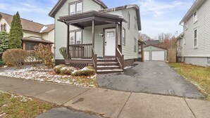 A two-story house with a porch, a garage, and a driveway. - Modern 4 BR/2 Bath House near University of Rochester (Rochester)