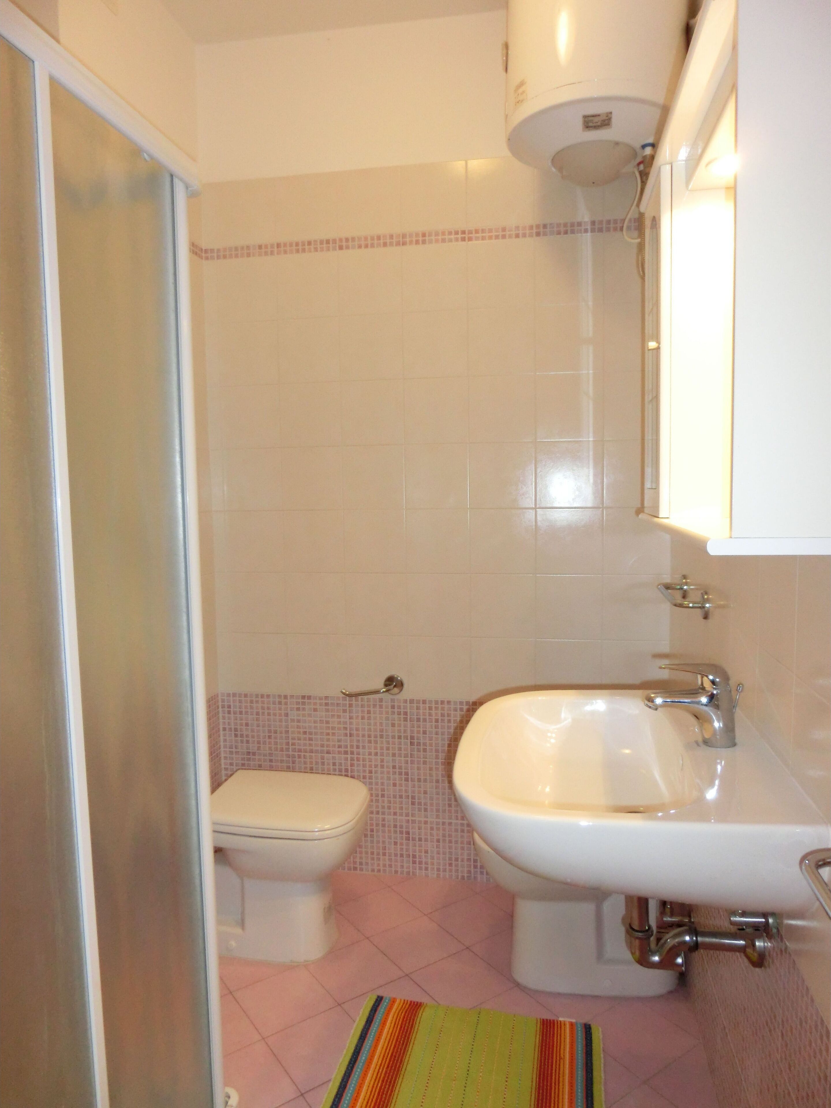 A bathroom with a toilet, sink, and shower.