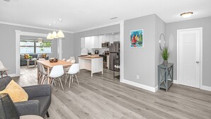 A modern kitchen with white cabinets, a wooden island, and stainless steel appliances.