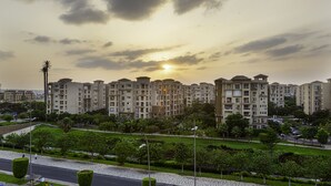 A residential complex with multiple apartment buildings, a well-maintained lawn, and a paved road.