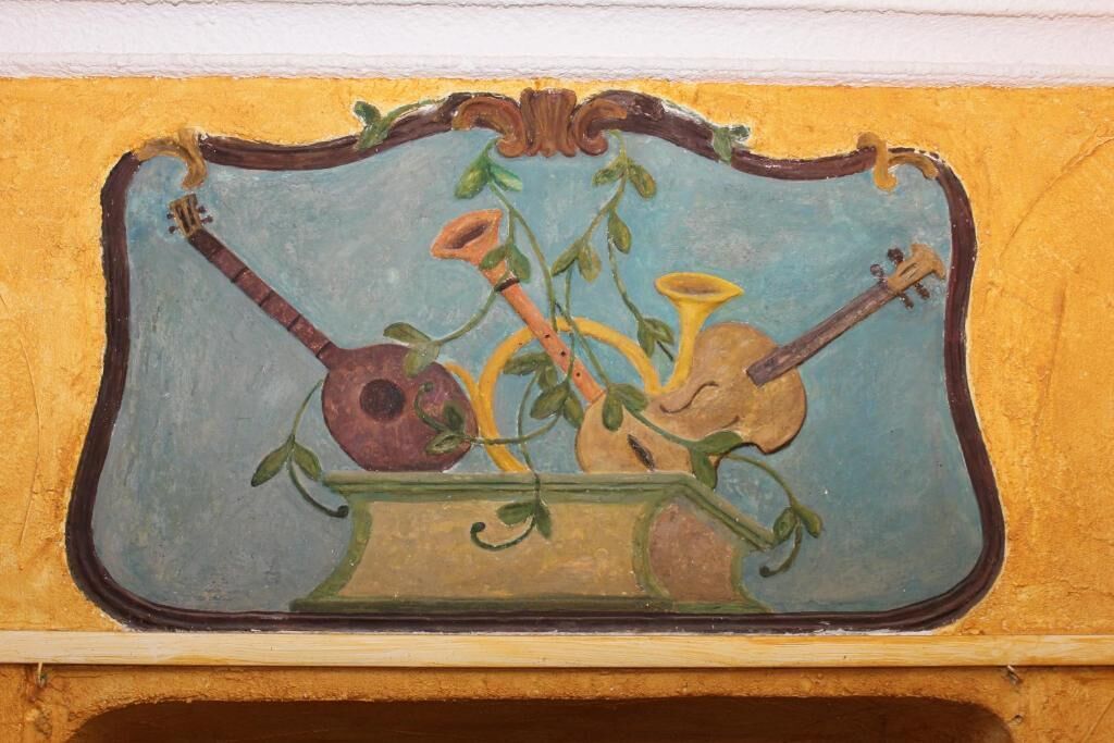 A wall mural with a guitar and a pot of flowers.