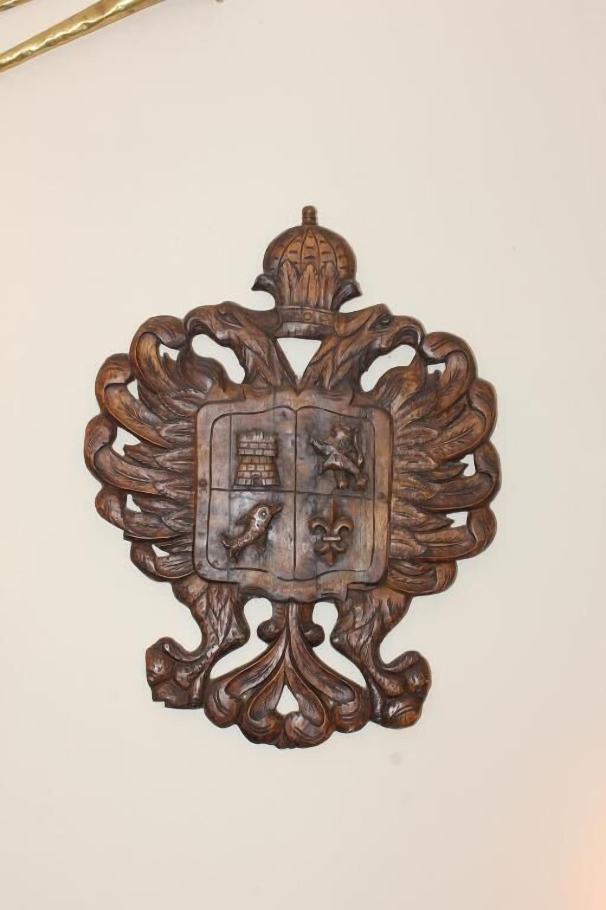 A decorative wooden plaque with intricate carvings and a shield emblem.