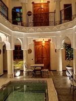 Un patio amplio con piscina, una puerta de madera y una mesa con sillas.