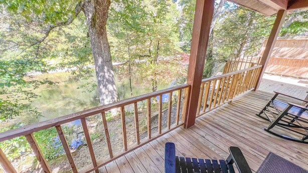 Une terrasse en bois dotée d’une rambarde, offrant une vue sur un paysage naturel.