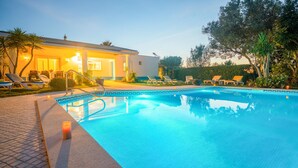 A swimming pool with lounge chairs and a building in the background.