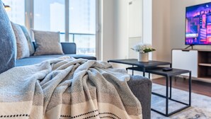 Un salon moderne avec un canapé, une table basse et un téléviseur.