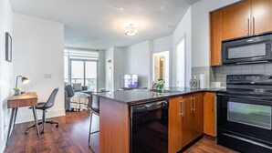 Une cuisine moderne avec des meubles en bois, un four encastré et un four à micro-ondes.