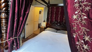 A bedroom with a four-poster bed, a wooden headboard, and a large window with curtains. - Central Bath Georgian Rooms (Bath)