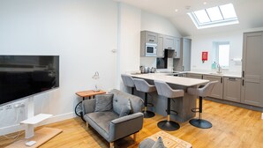 A modern kitchen with grey cabinets, a central island, and a large window above the sink.