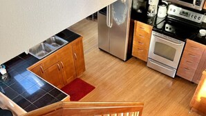 Een keuken met een roestvrijstalen koelkast, een oven en een magnetron.