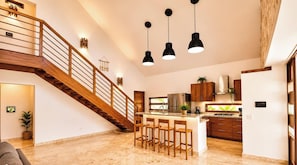 A spacious kitchen with a central island, wooden staircase, and pendant lighting. - House with swimming pool 300m from Las Ballenas beach (Las Terrenas)