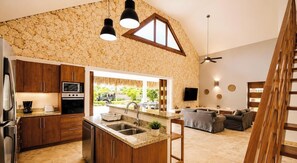 A kitchen with granite countertops, wooden cabinets, a built-in oven, and a large island with a sink. - House with swimming pool 300m from Las Ballenas beach (Las Terrenas)