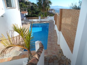 A pool area with a view of the sea, a staircase, and a palm plant. - Villa 'Torre Del Mar' with Sea View, Wi-Fi and Air Conditioning (Salobreña)