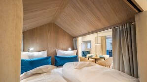 A hotel room with two beds, a dining area, and a view of the outside. - Studio Apartment 'Avia Living Elisabeth' with Mountain View and Wi-Fi (Brunico)
