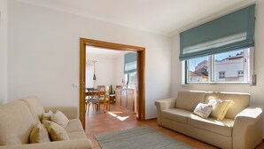 Ein Wohnzimmer mit einer Couch, einem Essbereich und einer Küche im Hintergrund.