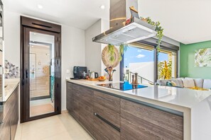 Una cocina moderna con una isla integrada, una cafetera y vistas al área de estar.