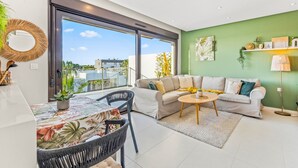 A modern living room with a sofa, coffee table, and dining area. - Apartment 'Casa Marysol' with Sea View, Wi-Fi and Air Conditioning (Orihuela)