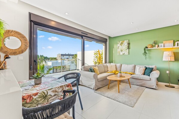 A modern living room with a sofa, coffee table, and dining area.