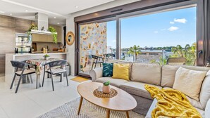 A modern living area with a sofa, coffee table, dining table, and chairs. - Apartment 'Casa Marysol' with Sea View, Wi-Fi and Air Conditioning (Orihuela)