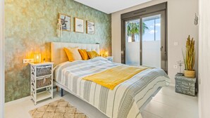 A bedroom with a bed, bedside tables, wall art, and a view of the outdoors. - Apartment 'Casa Marysol' with Sea View, Wi-Fi and Air Conditioning (Orihuela)