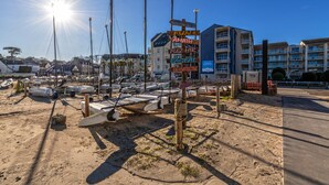 Eine Strandlage mit einem Schild, das Annehmlichkeiten wie eine Bar, ein Restaurant und den Standort anzeigt.