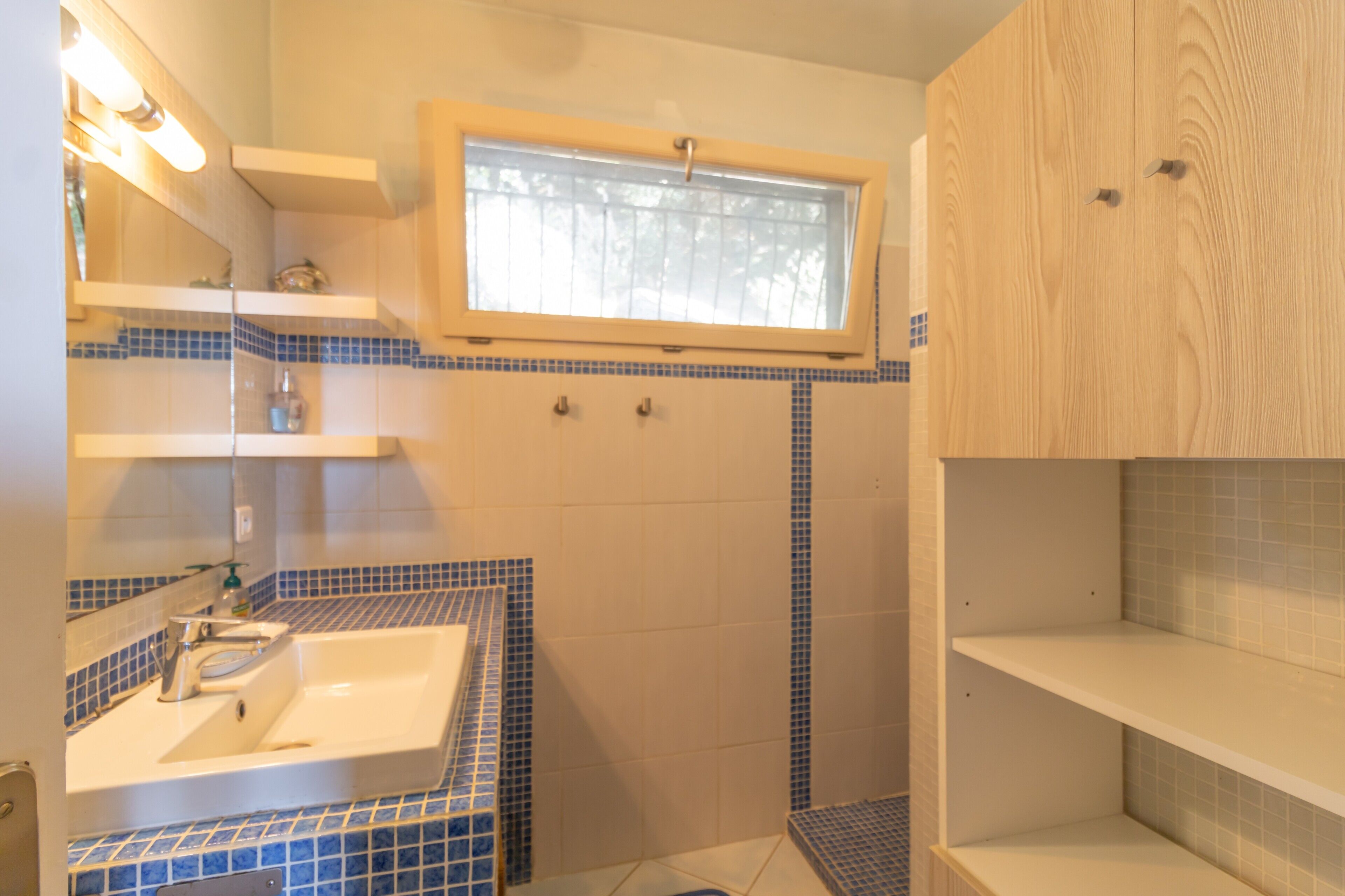 Une salle de bain équipée d’un lavabo, d’un miroir et d’un espace douche.